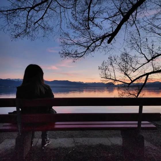 Woman sitting on a bench at a lake